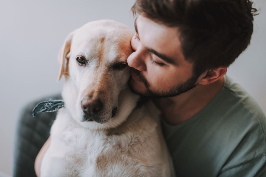 uomo avvicina il viso al muso del suo cane