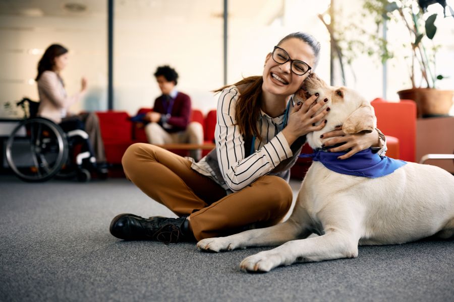 ragazza sorridente abbraccia un cane durante la pet therapy